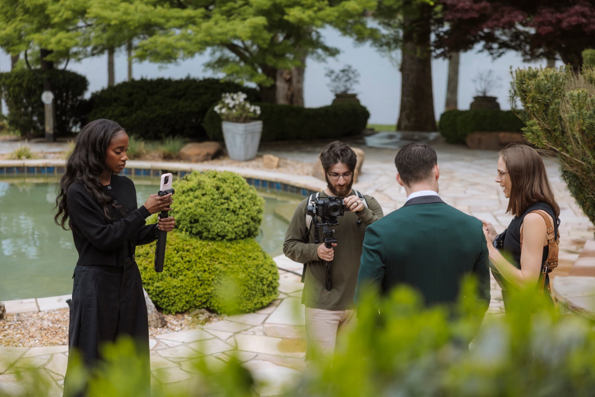 Judea filming a couple with the team at the pool
