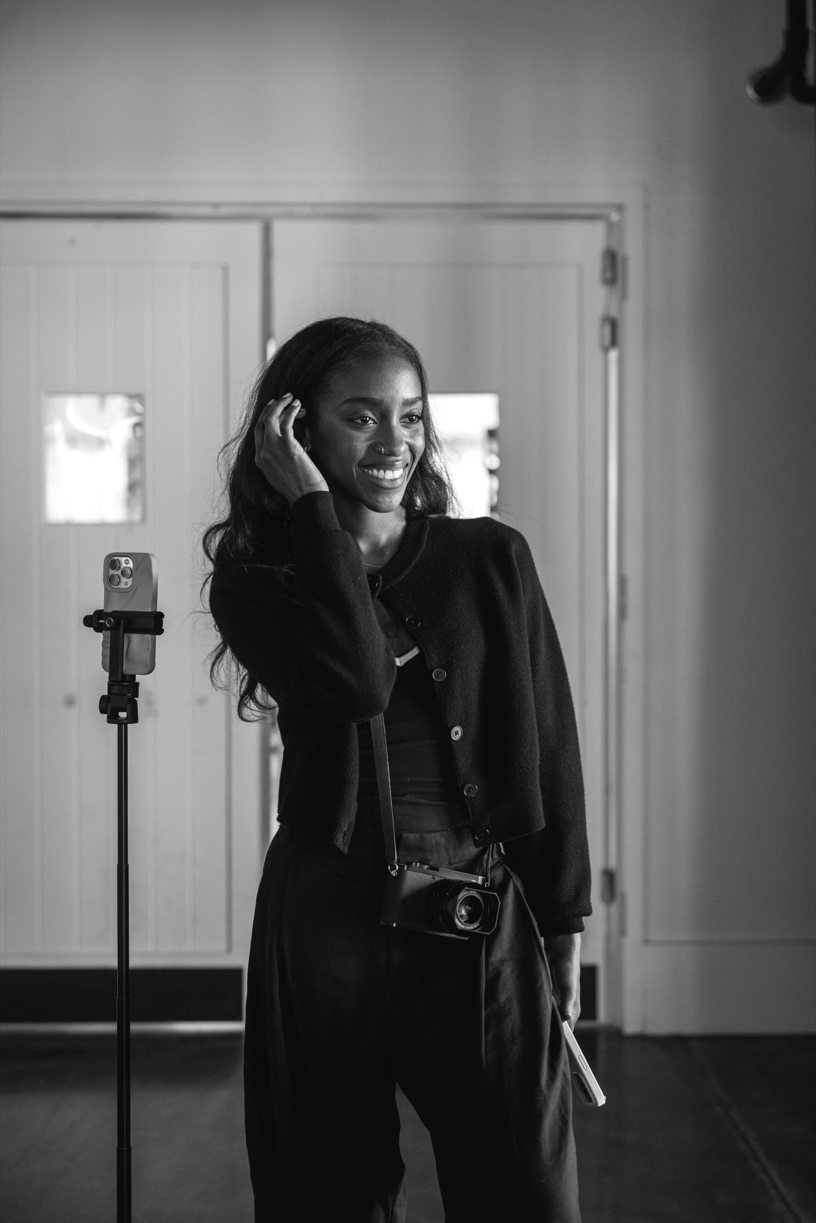 Black and white portrait of Judea tucking hair behind her ear